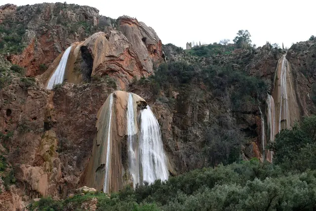 Waterfalls pouring over red rock cliffs at Imouzzer Ida Outanane